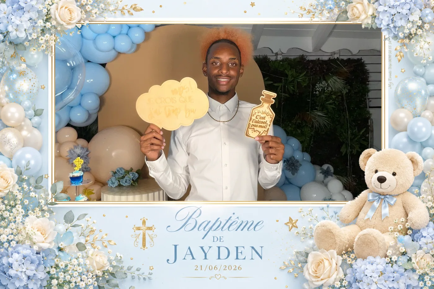 Baptême : un invité pose avec les accessoires nuage et biberon assortis au décor bleu et doré