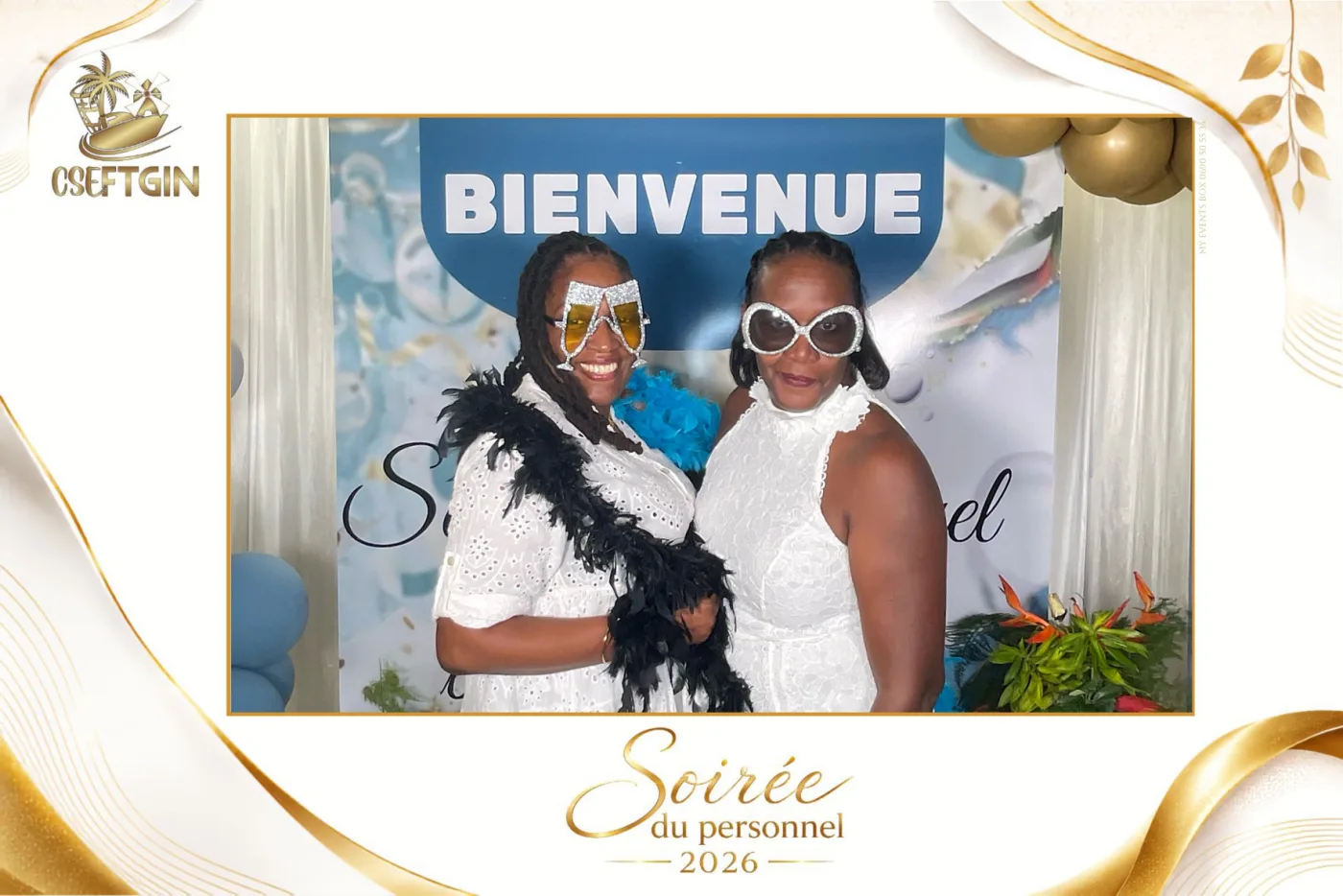 Soirée du personnel : deux collègues posent avec boa et lunettes devant la borne photo