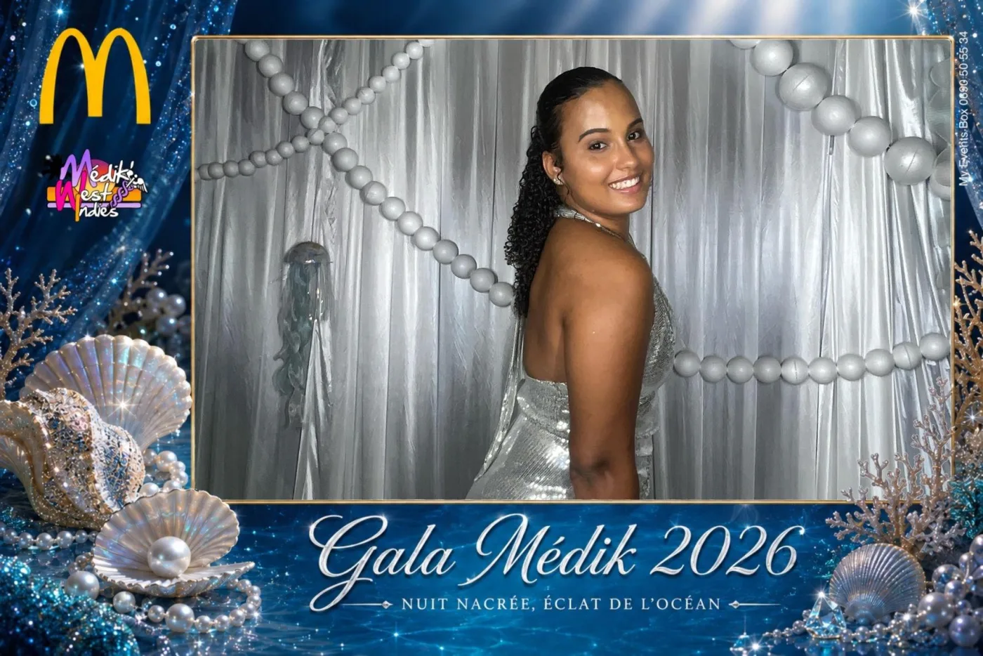 Cadre bleu océan à coquillages et perles pour le gala d'une enseigne de restauration rapide : une invitée en robe à sequins argentés pose devant un drapé argenté orné de perles géantes