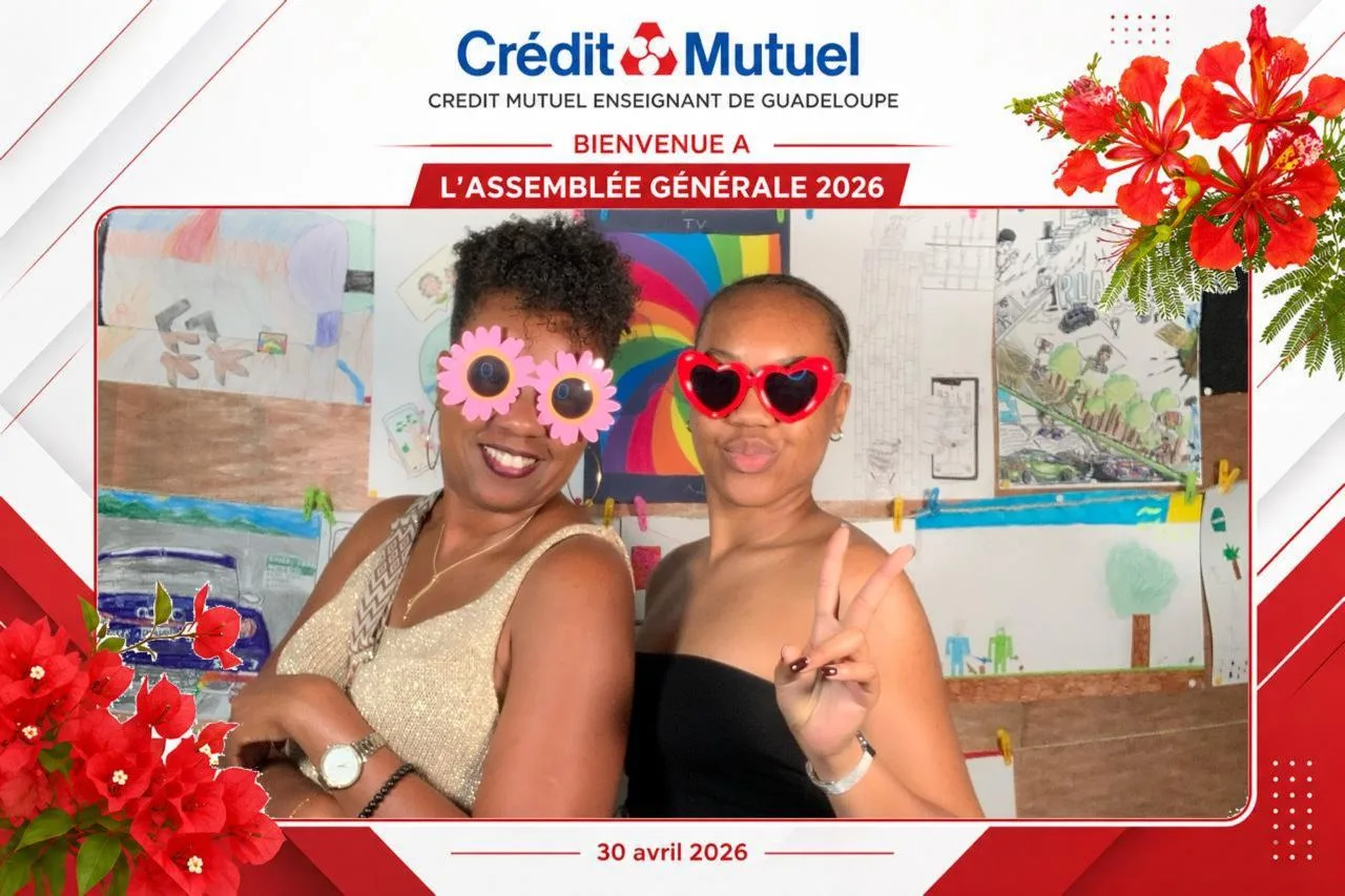 Tirage aux couleurs du Crédit Mutuel Enseignant de Guadeloupe, « Bienvenue à l'Assemblée Générale 2026 » : deux participantes avec lunettes fantaisie devant un mur de dessins